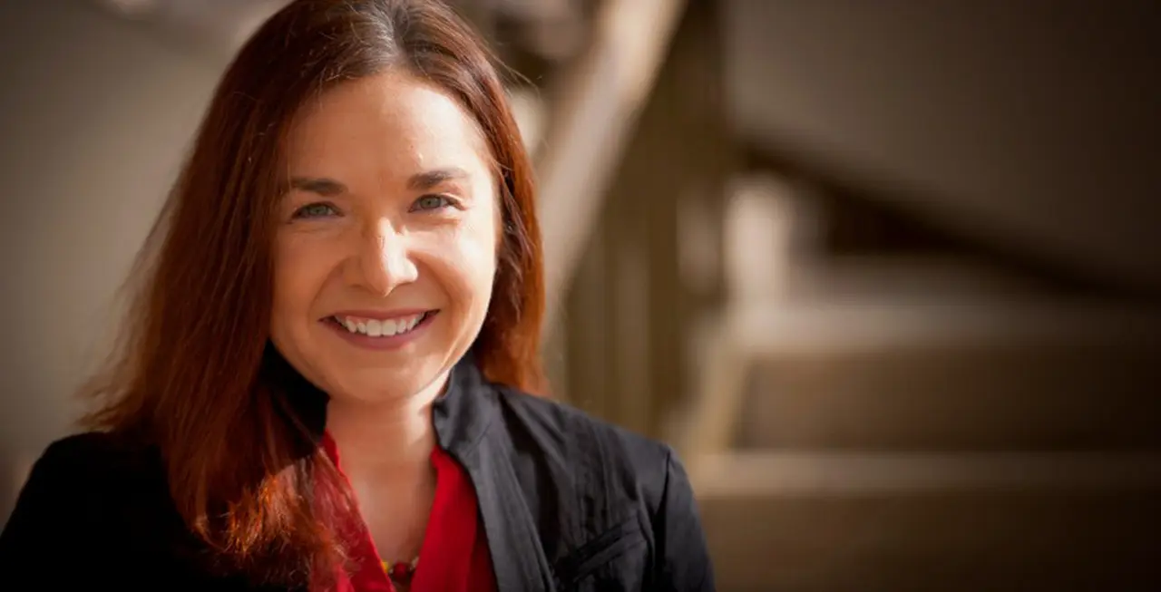 Wide rectangular photo, with red-brown-haired Caucasian woman on left with UCLA Luskin Center for Innovation and UCLA Luskin School of Public Affairs in white text at bottom right of image