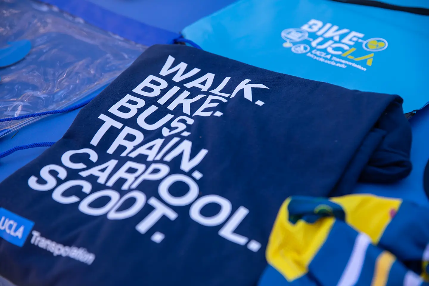 Dark blue shirt with words Walk.Bike.Bus.Train.Carpool.Scoot. and then UCLA Transportation